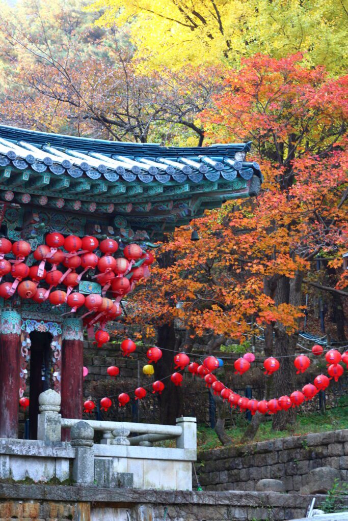 Fall colours of Mt. Gwanak with a view of a roof of a temple 