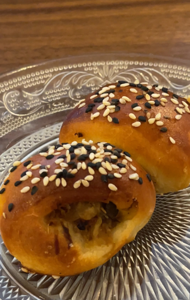 stuffed cabbage bread rolls with sesame seeds on top on a clear plate in a restaurant in krakow