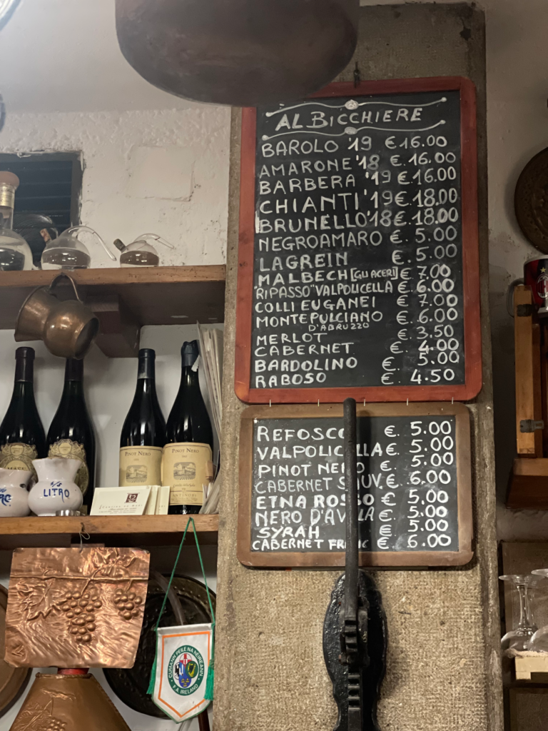 a wine menu with wine bottles surrounding it with prices ranging from 2-5 euro