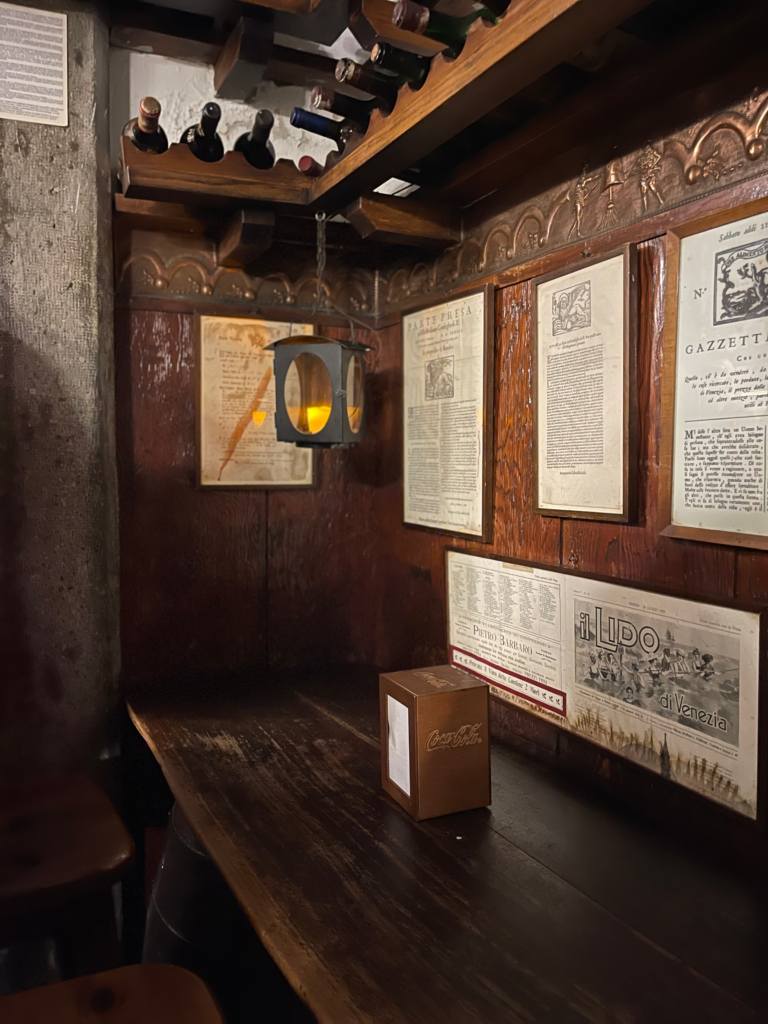 A seating table with wooden finish and venetian paitings of gondoliers on the wall