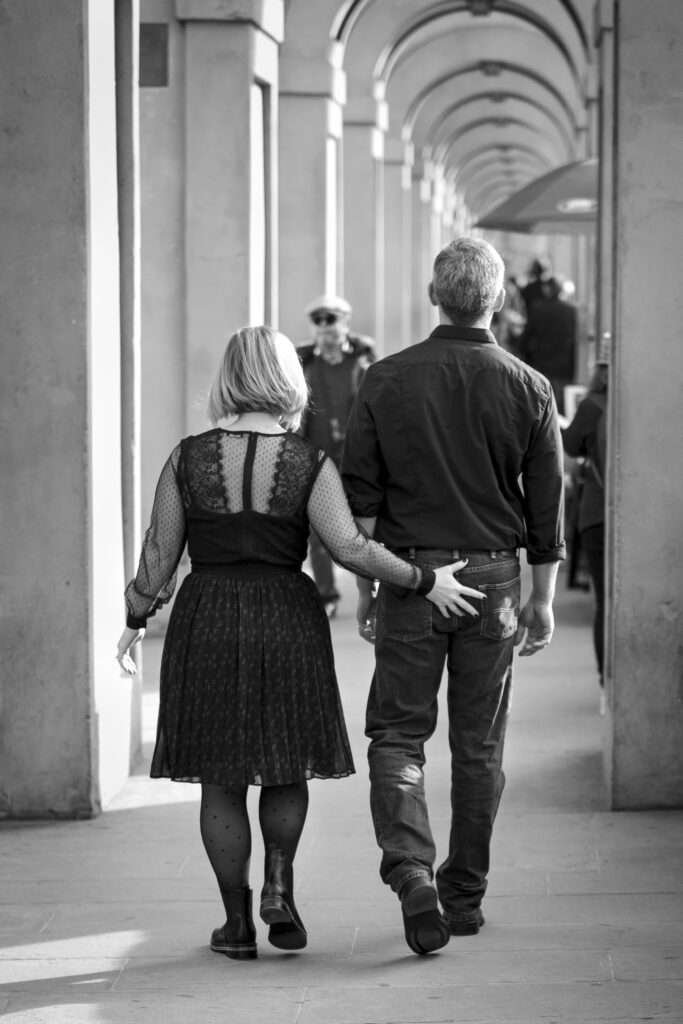 Couple walking down the streets of Florence Italy. Wife grabbing husbands butt.