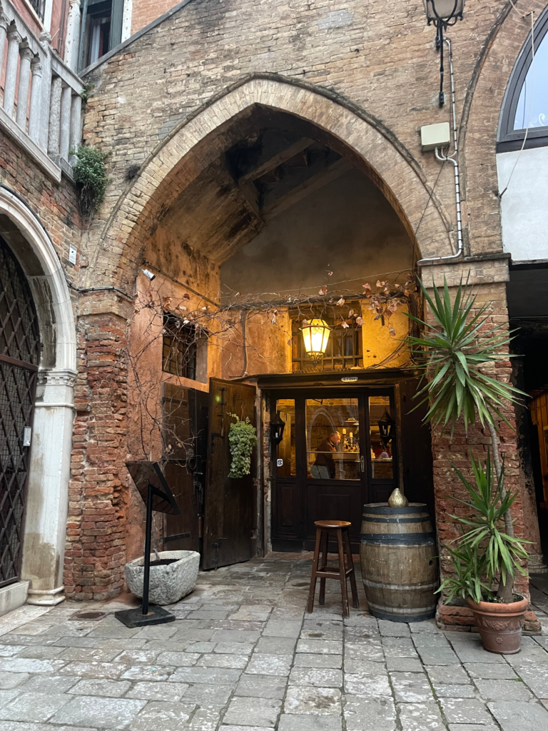 The facade of Taverna Al Remer in Venice, Italy with beautiful red brick and dim lighting