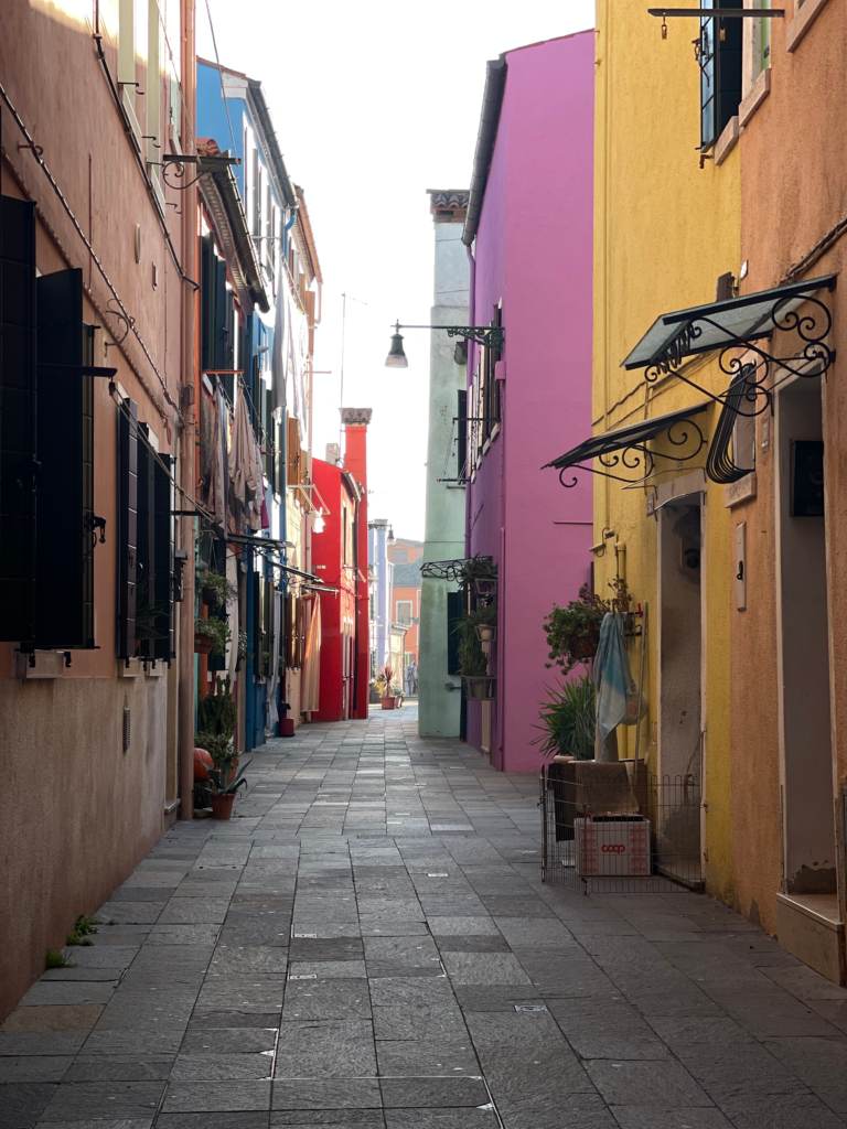 quiet alley way with colorful houses in burano italy