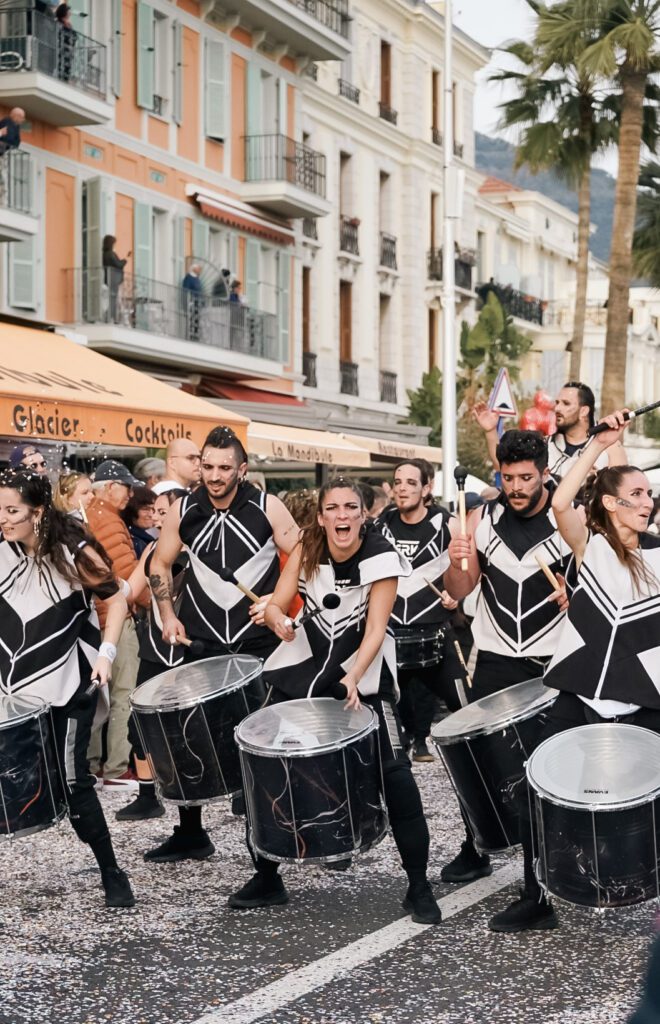 A band participating in the Fete Du Citron plays the drums. Emotion is eminating from their faces