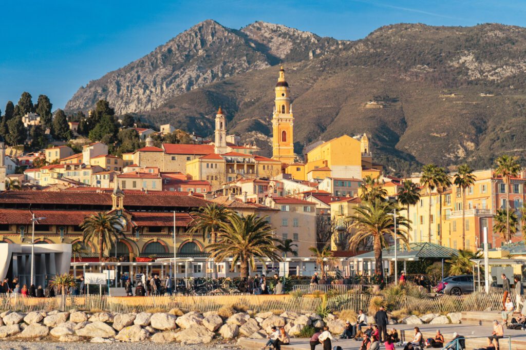 The bell tower of menton with the Mercantour Mountains in the back. Golden Hues reflect the Old Town. 