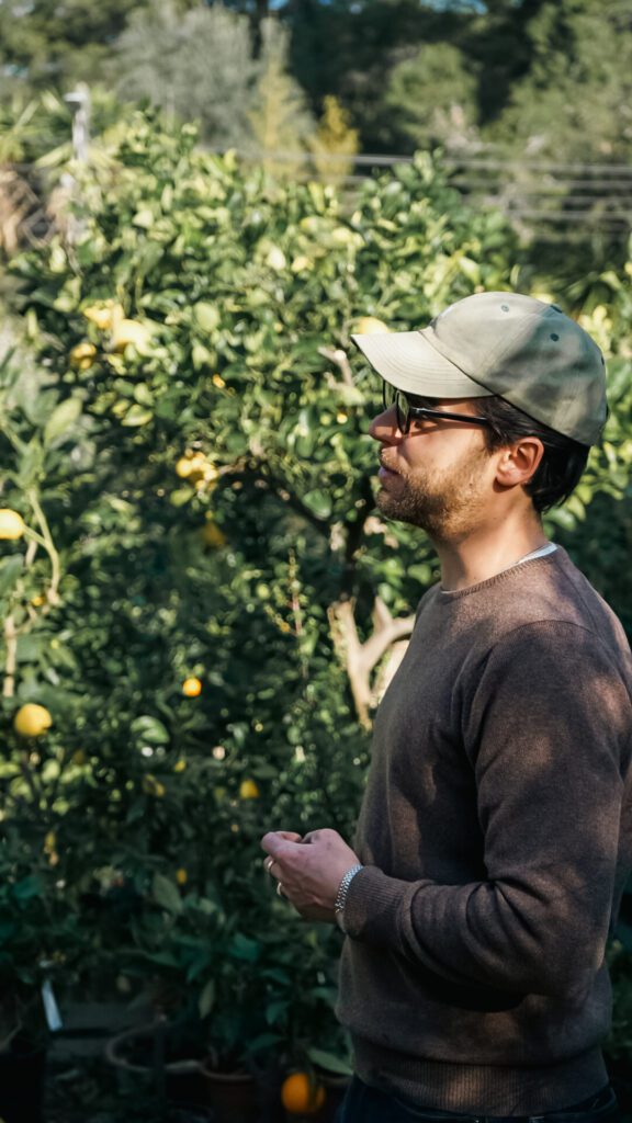 Man with a ball cap on and in a grey shirt leading a tour at Maison Gannac