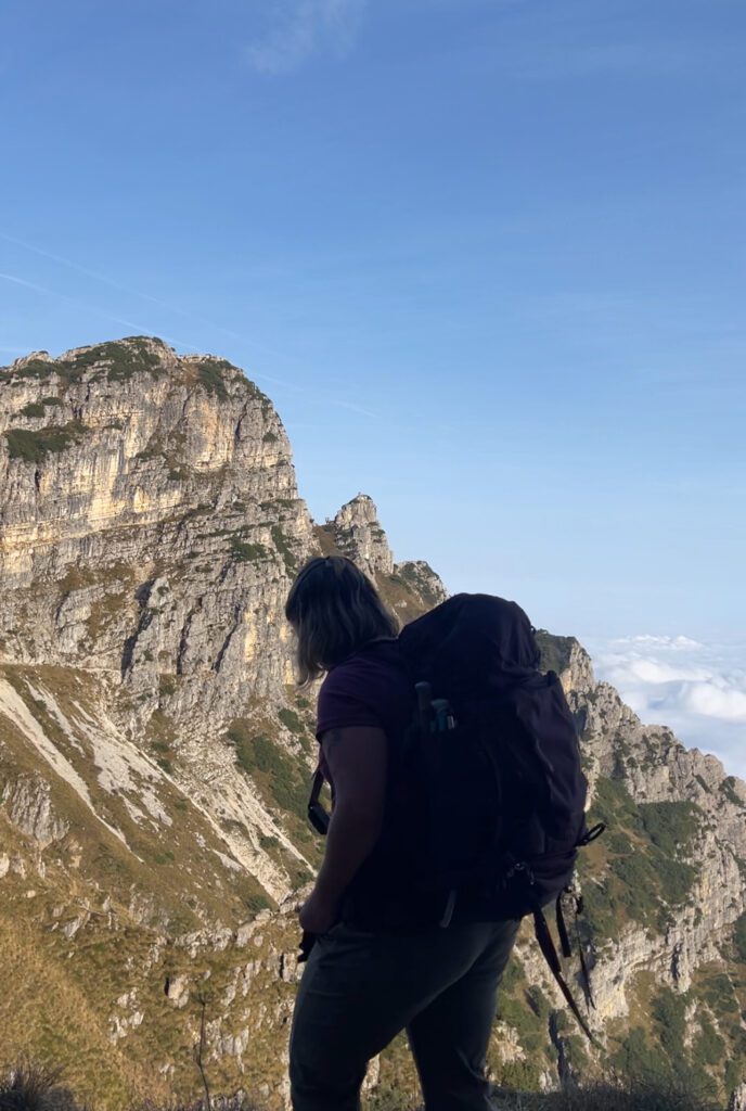 A shadow of a woman in front of a mountain with blue sky