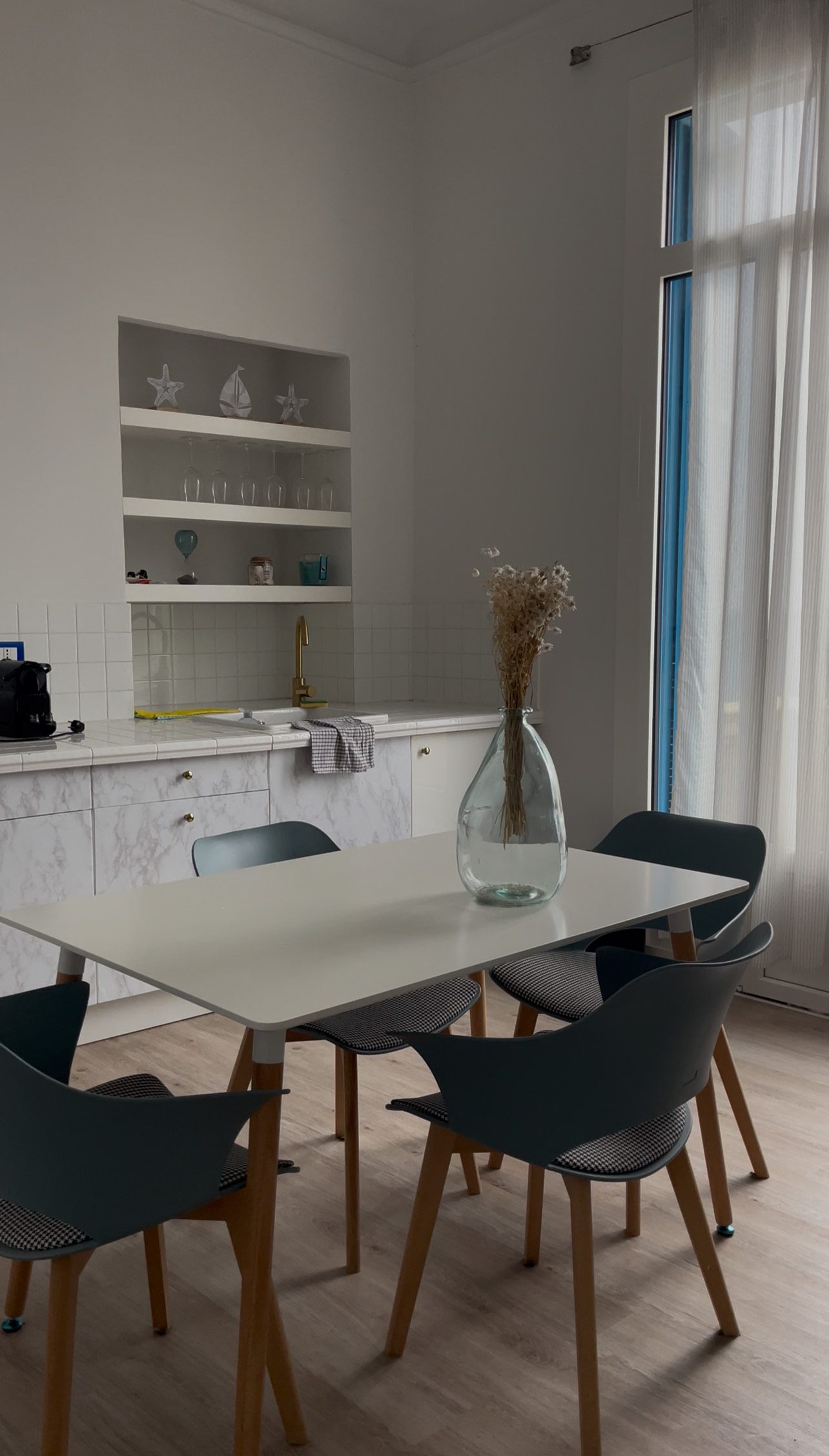 Kitchen with a table an chairs and decorative bush in a glass vase