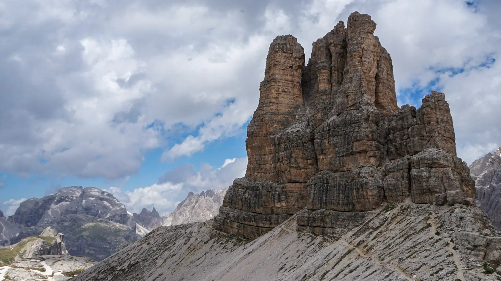 Sasso di Sesto rises up through the horizon. Jagged peaks appear to be touching the blue skies.