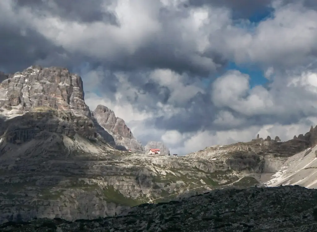 Dolomites rise up from the background as the sun highlights the beautiful Rifugio Locatelli