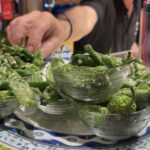 A plate of Pintxos, Gernika Peppers is being served to a patron in Bar Casa Alcalda