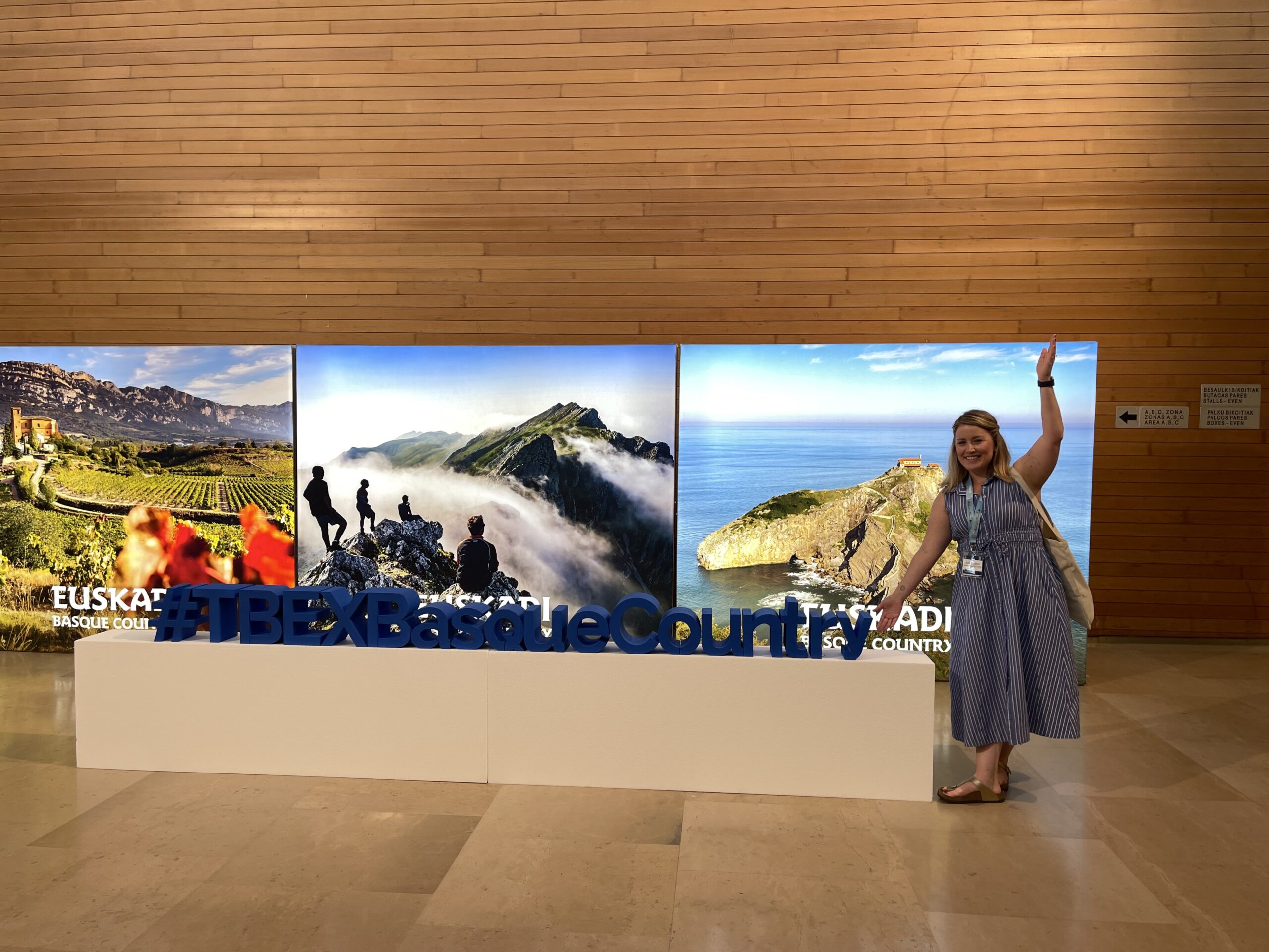 Blogger, Kimberly Kephart posing with TBEX Basque Country Signage in the Kursaal Convention Center