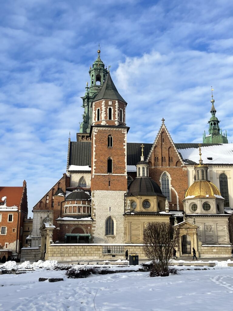 Wawel Castle, one of the best places to visit in Krakow stands out against the blue sky with its beautuful green roof. 