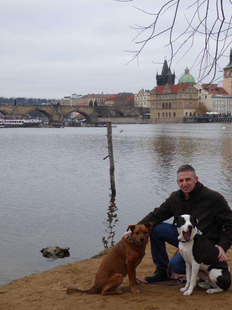 Photo of my husband with two dogs. Sometimes having your furry friends with you aids in Culture shock.
