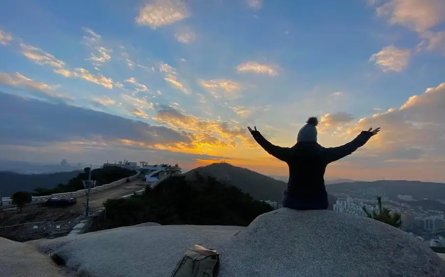 Author, Kimberly Kephart on top of Inwangsan Mountain in Korea as the sunsets