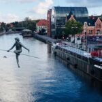 Statue of man on a roap that is strung across the vistula river in Bydgoszcz Poland