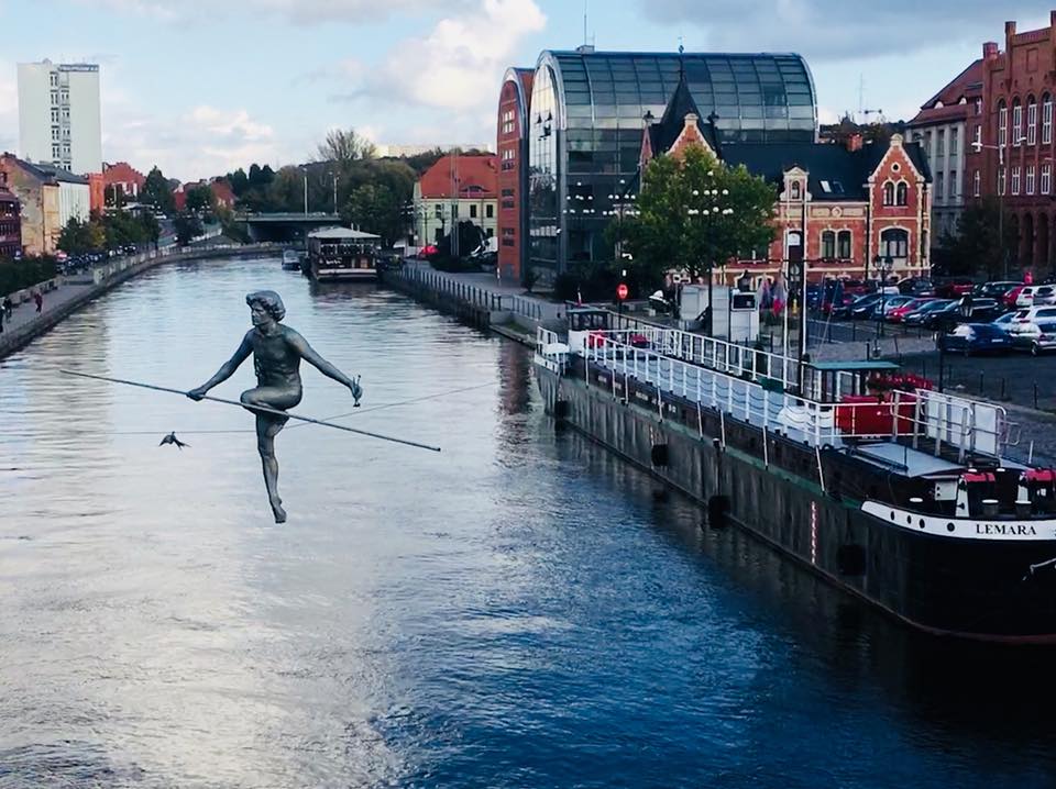 Statue of man on a roap that is strung across the vistula river in Bydgoszcz Poland