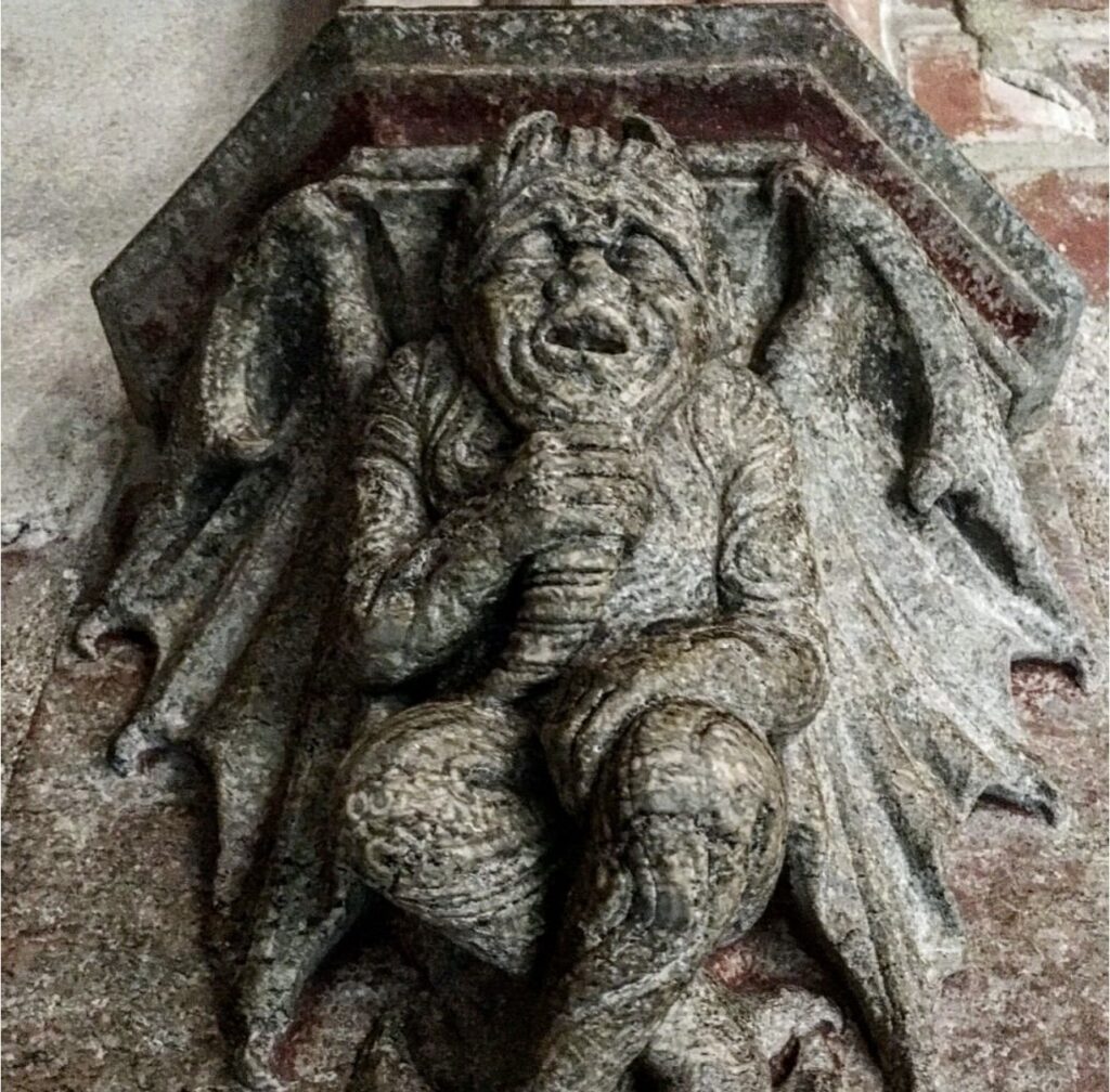 a grey stone gargoyle in Malbork castle