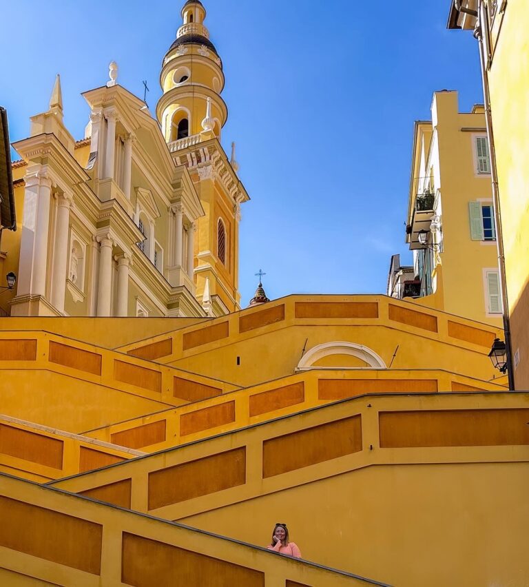 Woman standing on colorful yellow steps in Menton France