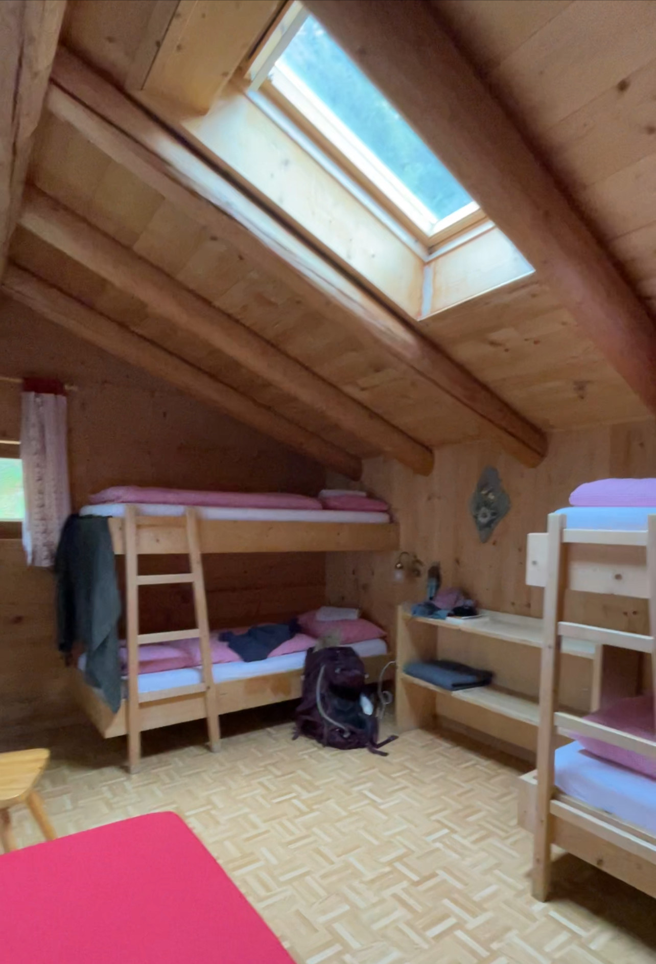 A room with bunkbeds and red and white checkered sheets and pillowcases