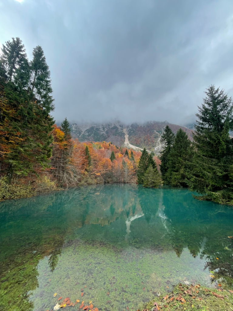 Mountain reflections in alpine lake along Sentiero Grandi Alberi hike in northern Italy