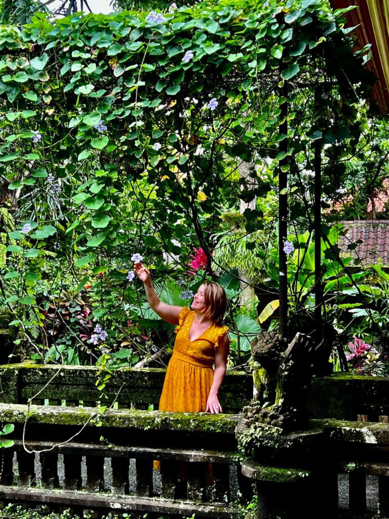 woman in a yellow dress standing on a brige with greenery at ARMA