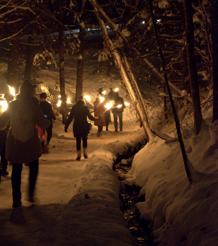 Participants holding torches on their way to the Ravenna Gorge Christmas Market