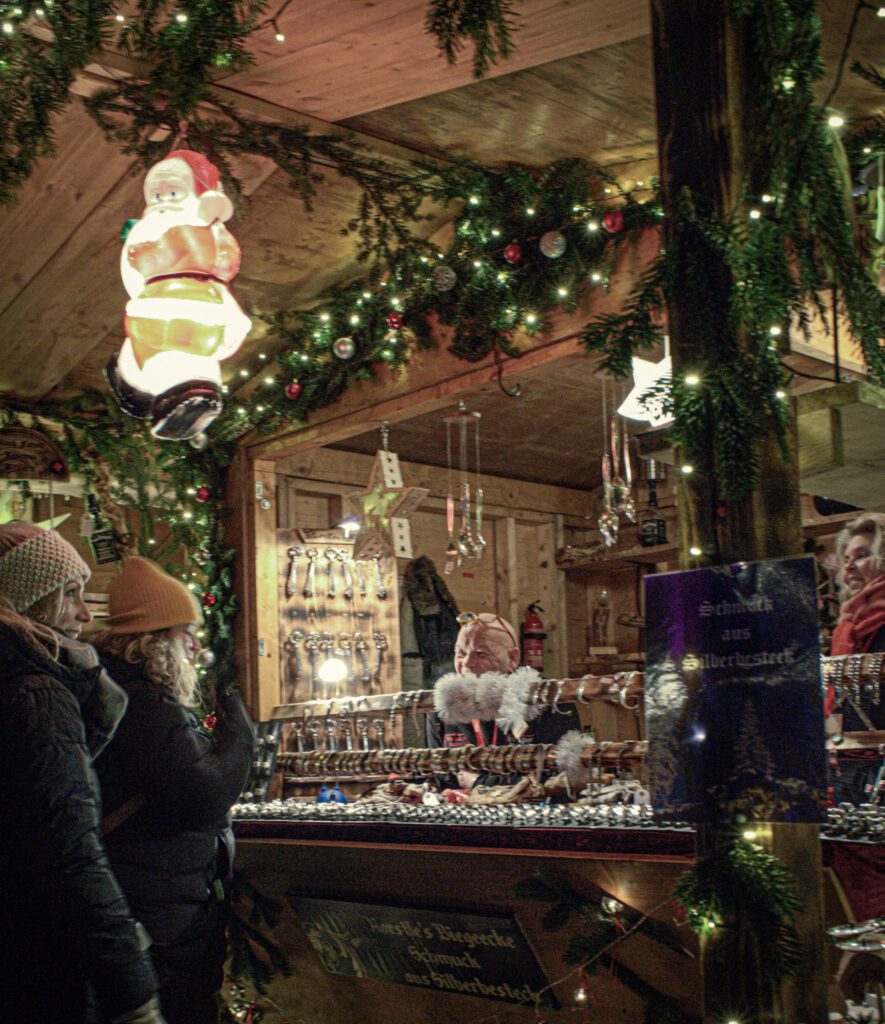 Market Stall with offerings. Surrounded by Christmas lights and greenery.