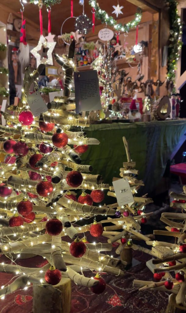 Christmas Market stalls selling local handicrafts, a Christmas Tree with red ornaments is sitting on a table at the Ravenna Gorge Christmas Market