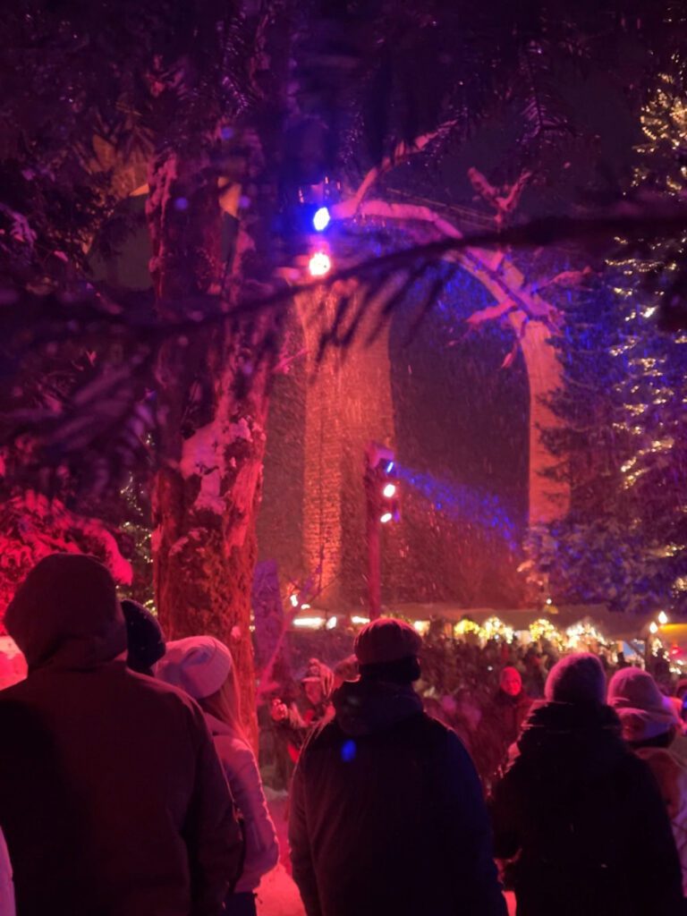 the Ravenna Gorge Christmas Market lit up with red lights in the snow