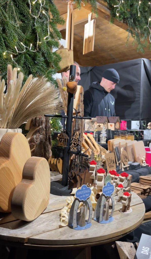 a man holding a wooden ornament at his stall in the ravenna gorge