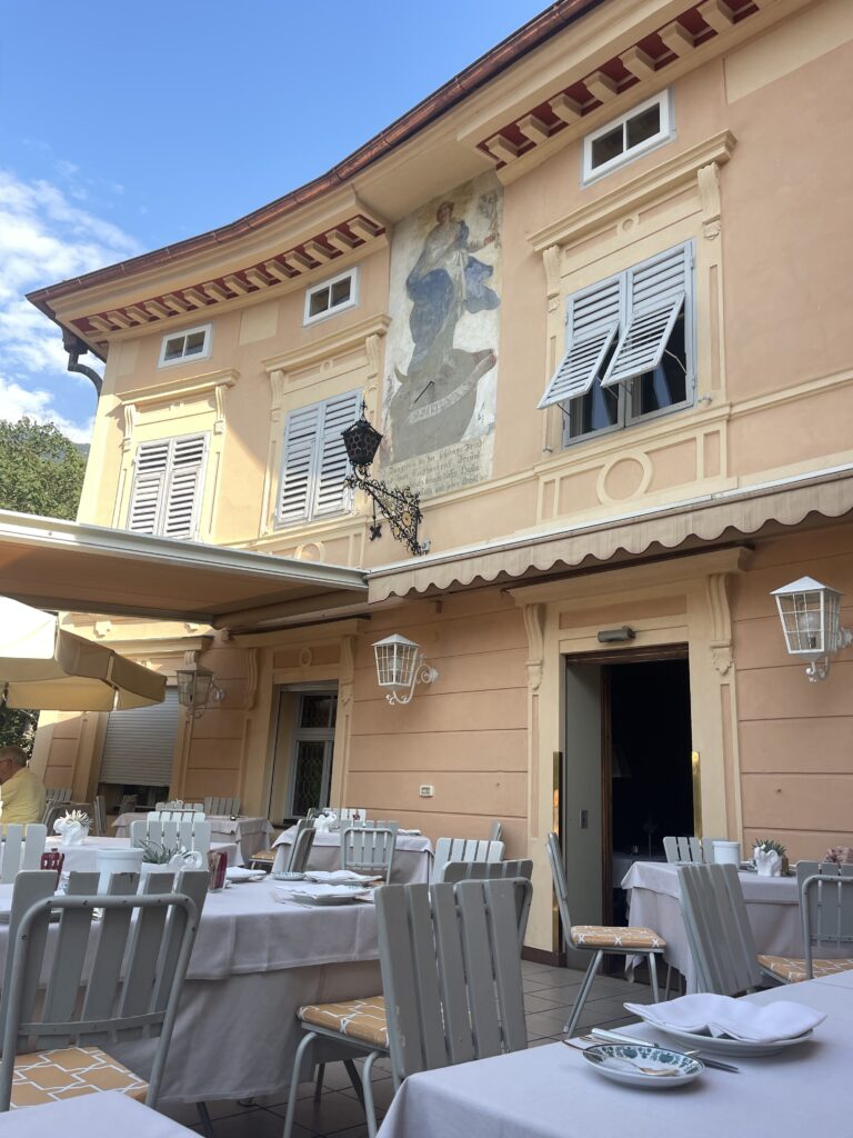 Orange facade of hotel elephant with white tables and chairs out on a balcony