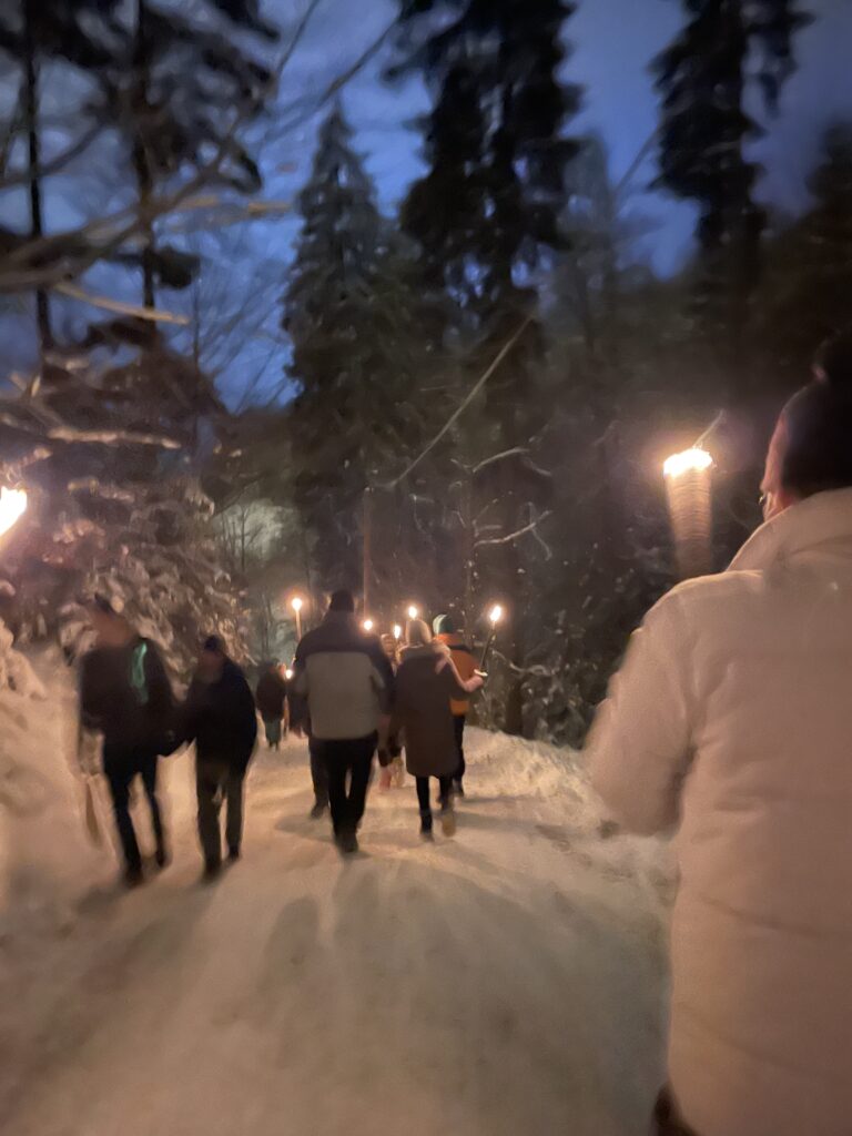 People holding torches on the way to the Ravenna Gorge Christmas Market
