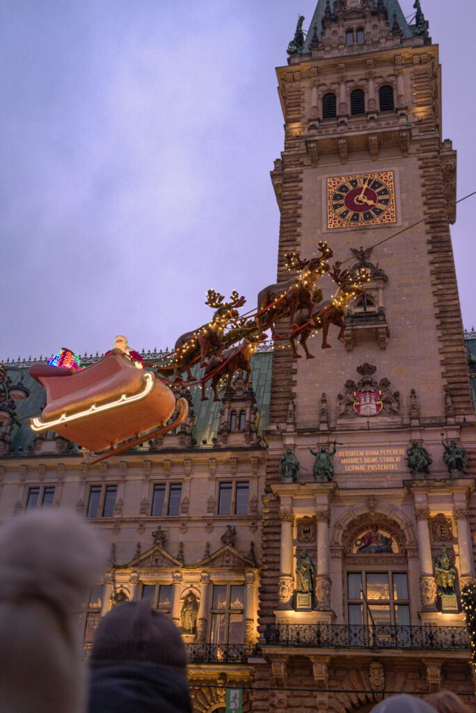 Santa in his sleigh with reindeer flying across the Rathausmarkt