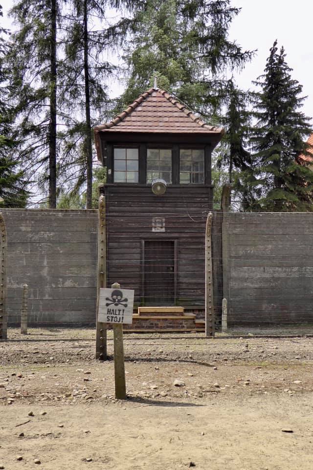 Picture of Auschwitz guard tower and a sign that says STOP!