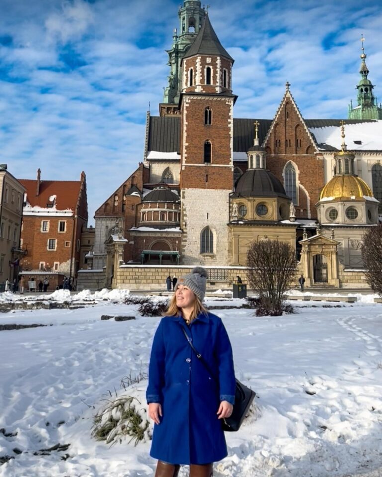 Woman in a blue coat standing in front of Wawel Castle