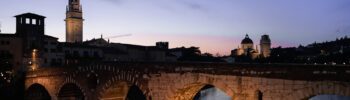 A bridge lit up with yellow light as the sunsets over a river