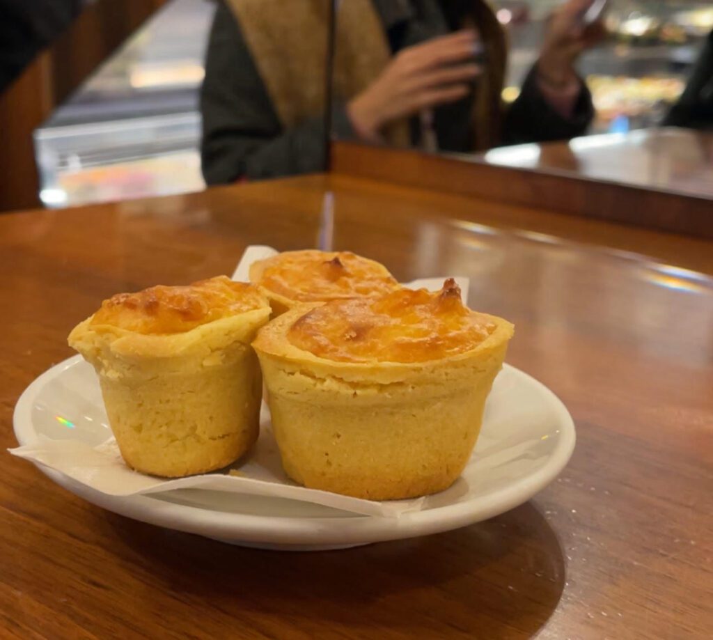 a traditional pastry sitting on a plate. The pastry is golden and filled with rice--it's called risini