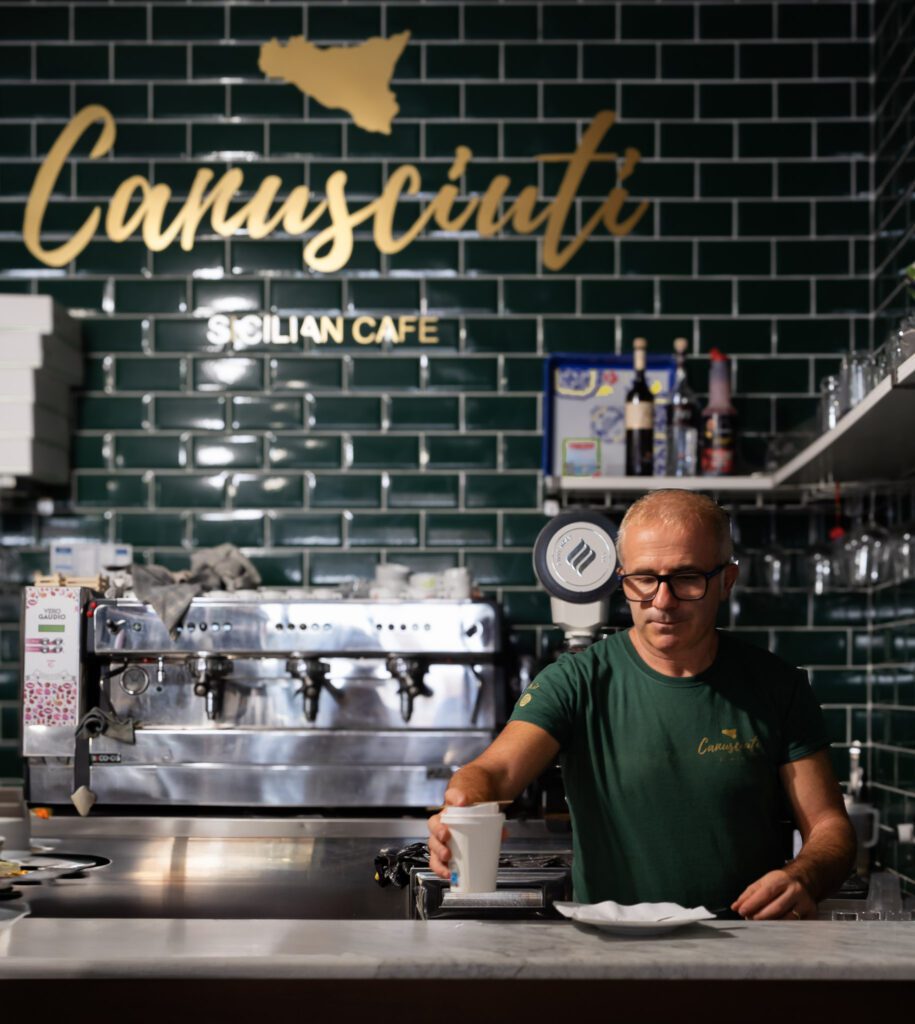 Man serving coffee at a restaurant in Catania
