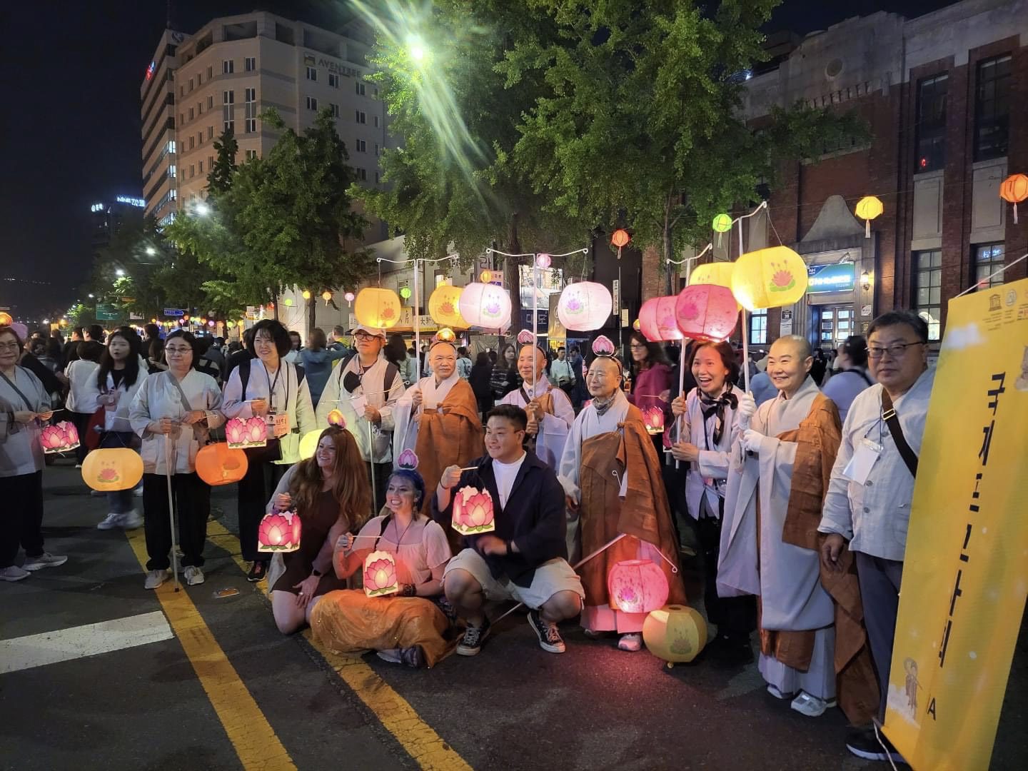 Group of people holding lanterns, some of them are buddhists