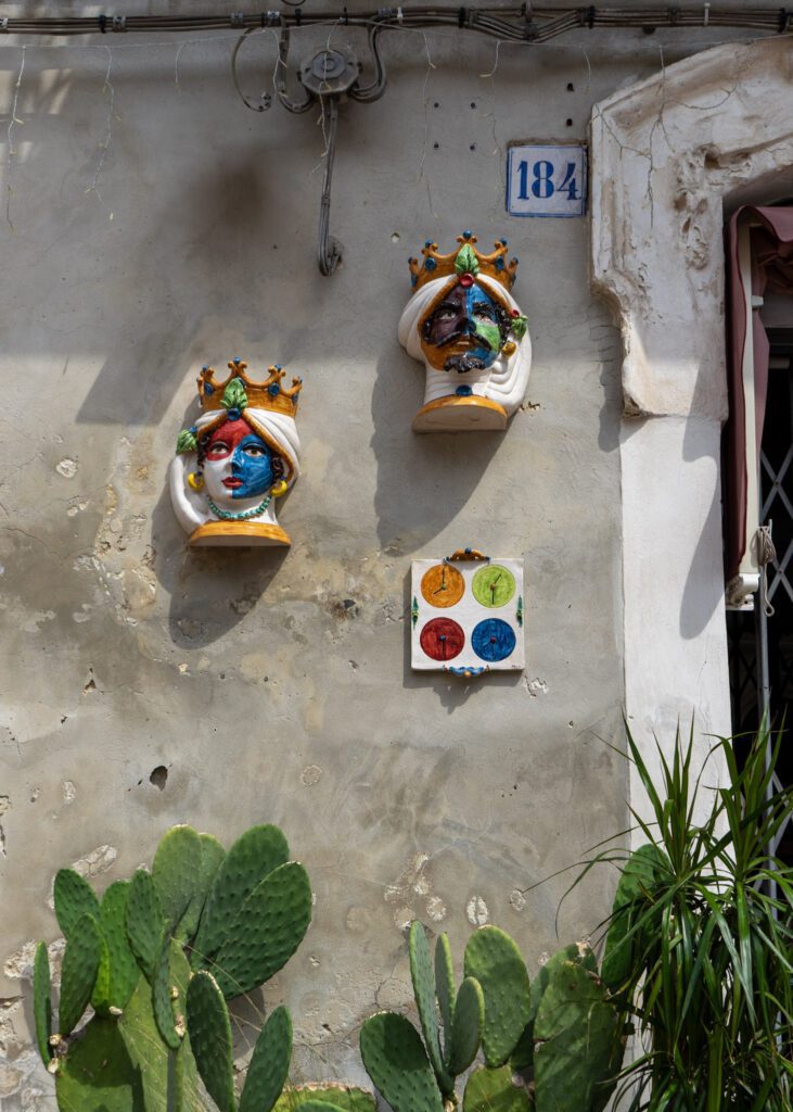 The famous heads of Sicily attached to a persons house in Modica.