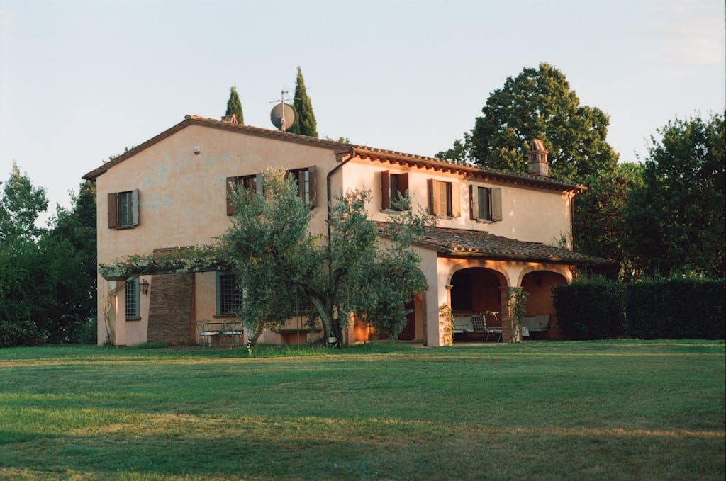 A charming rustic villa set in a peaceful Tuscan countryside, showcasing classic architecture and lush greenery.