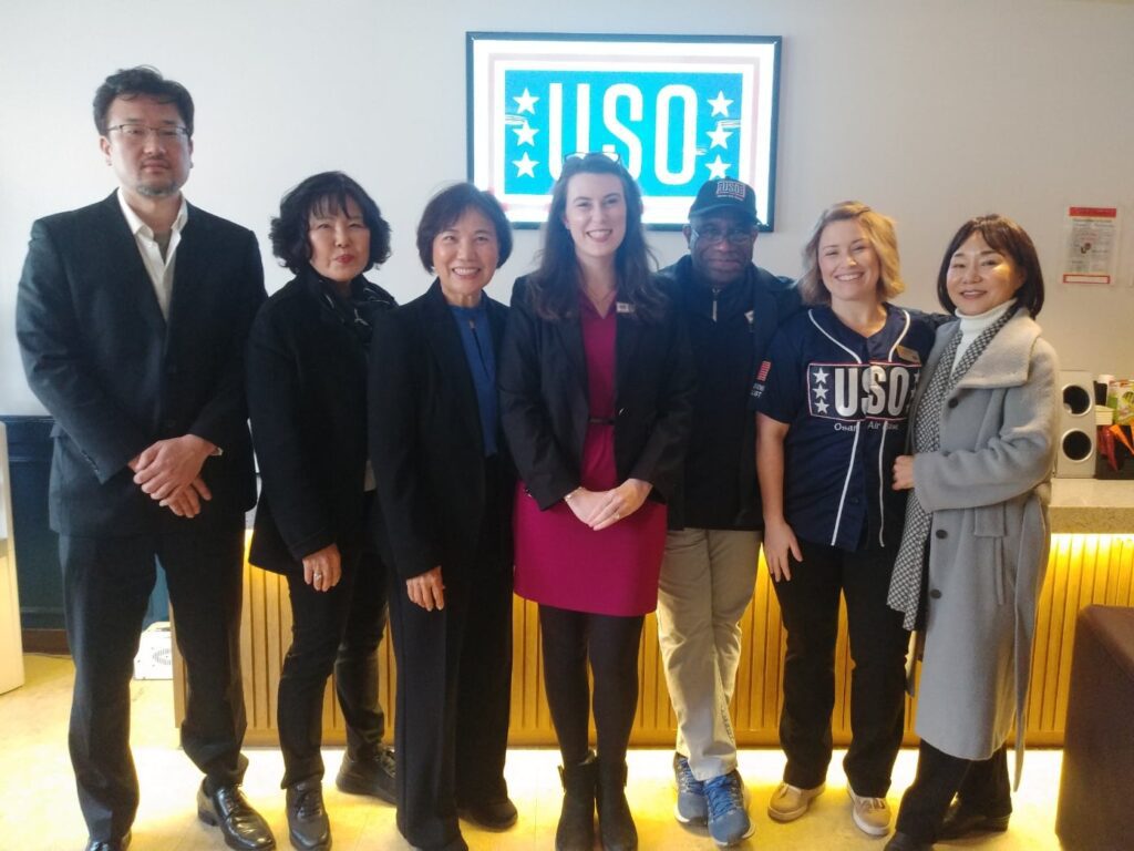 Men and women stand together after a meeting all wearing business clothed