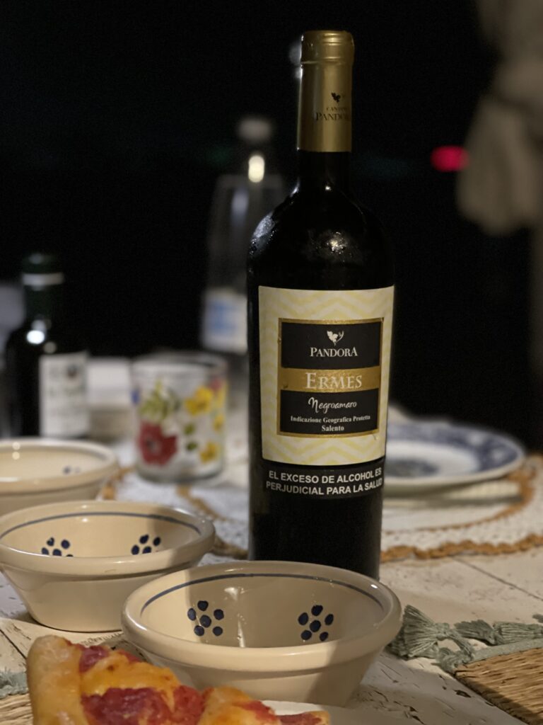 a bottle of italian wine sits on a table during a cooking experience in puglia