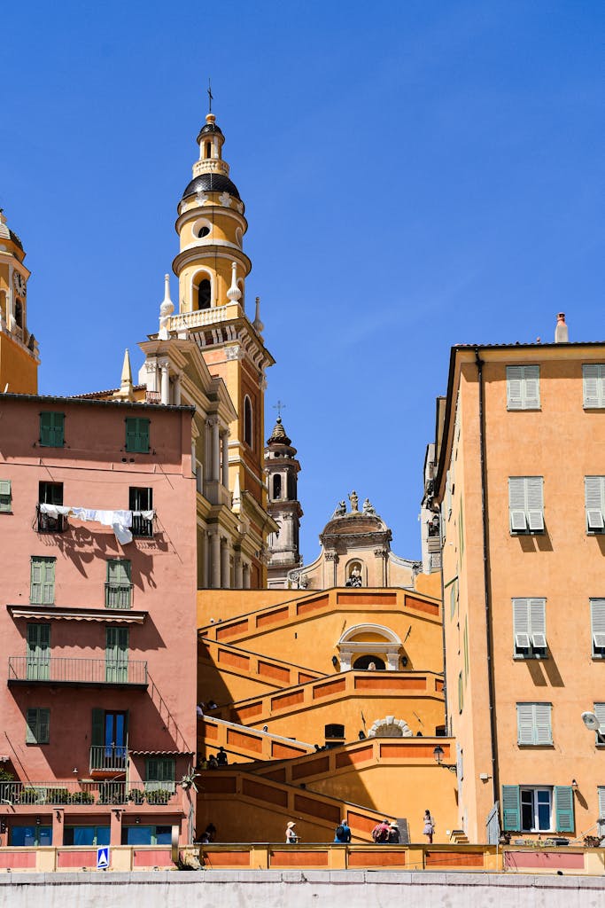 Scenic view of historic buildings and church towers in Menton, France on a sunny day.