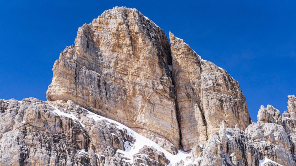 View of Forcella Averau. Big peak jutting out agains a blue sky in the Dolomites