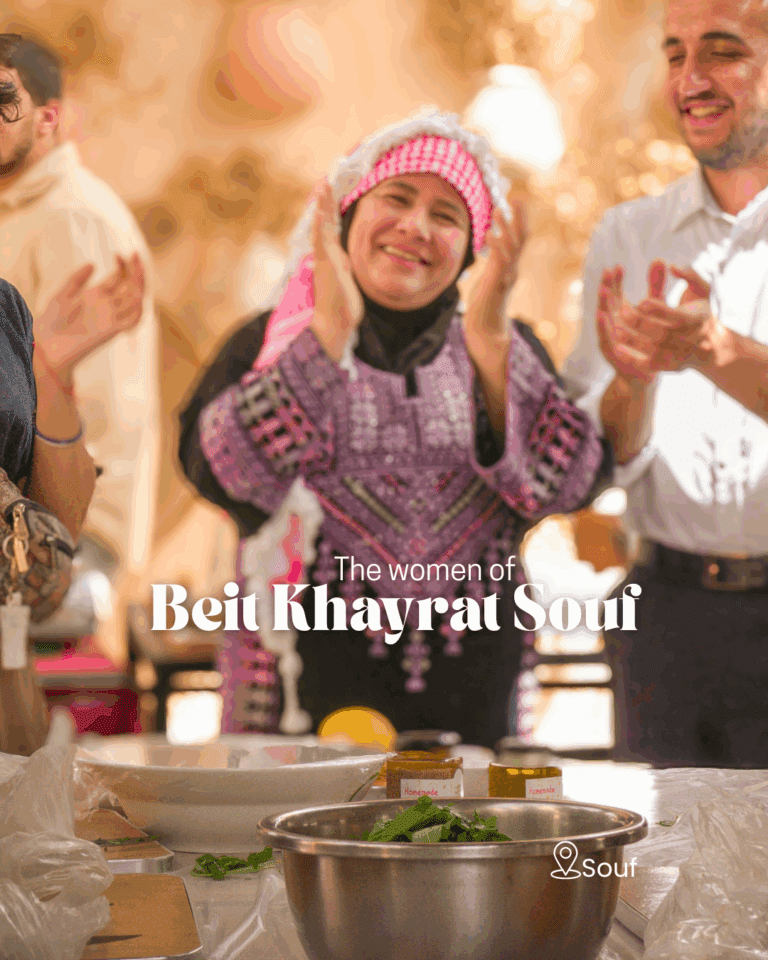Jordanian woman in traditional dress clapping at Beit Khayrat Souf cooking class.