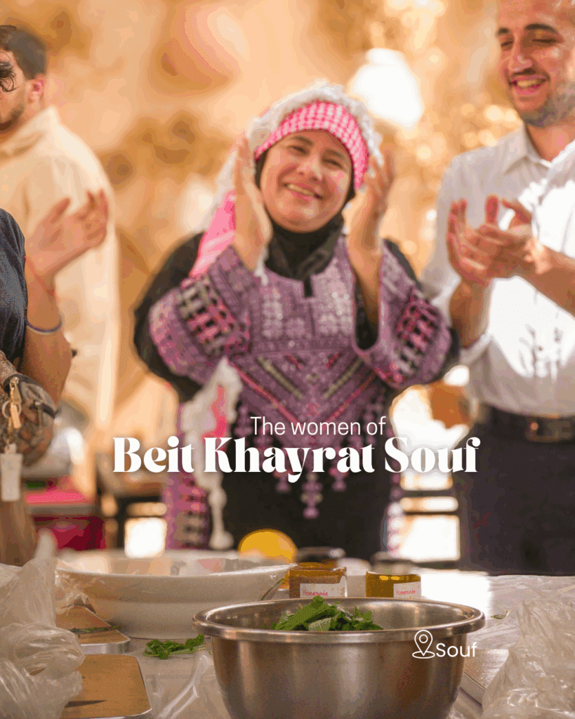 Jordanian woman in traditional dress clapping at Beit Khayrat Souf cooking class.