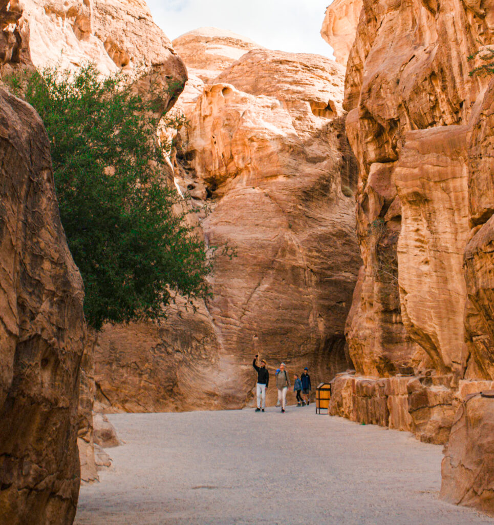 two people walk towards the camera in the siq in Petra