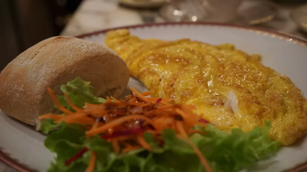 close up of breakfast at cafe carducci in Verona Italy. Eggs, Bread and Salad on a plate.